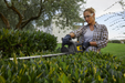 Stiga HT 700e 48v Cordless Hedgetrimmer - In Use Trimming Low Hedge-Top.